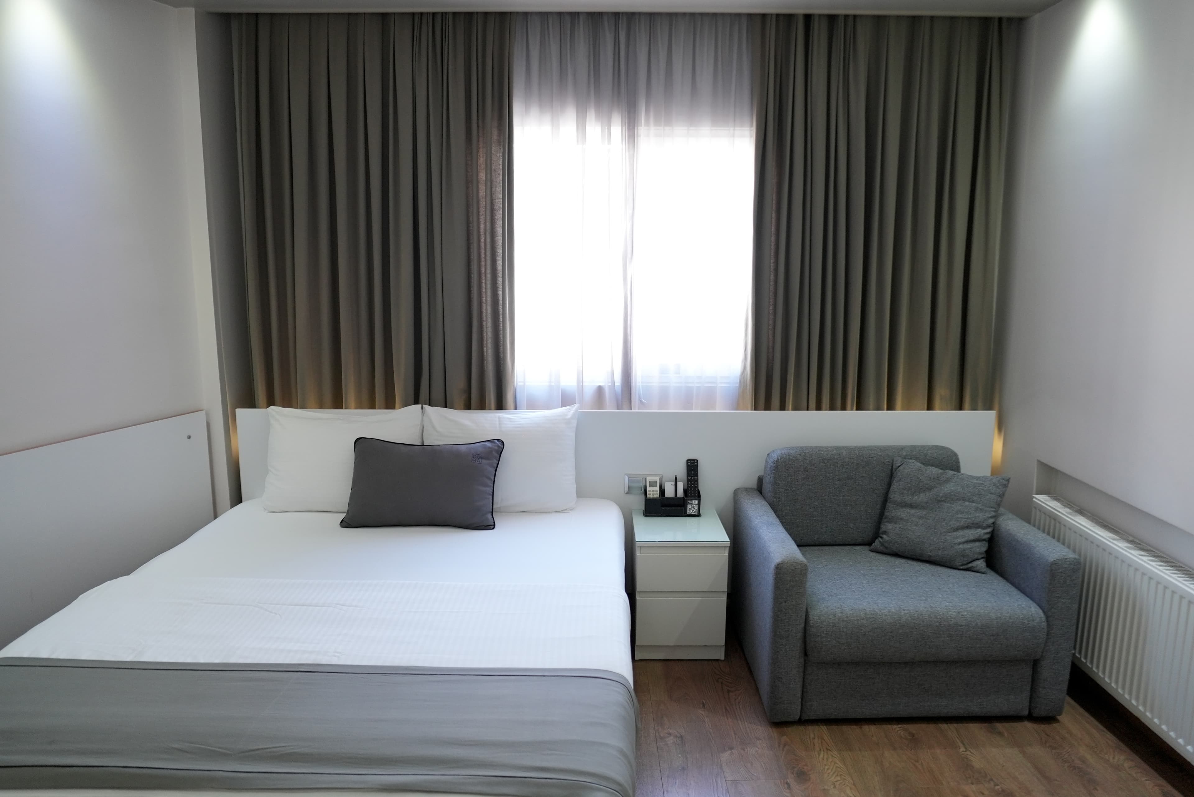 Family room: queen bed beside a sofa that folds out for a third guest, with a curtained window